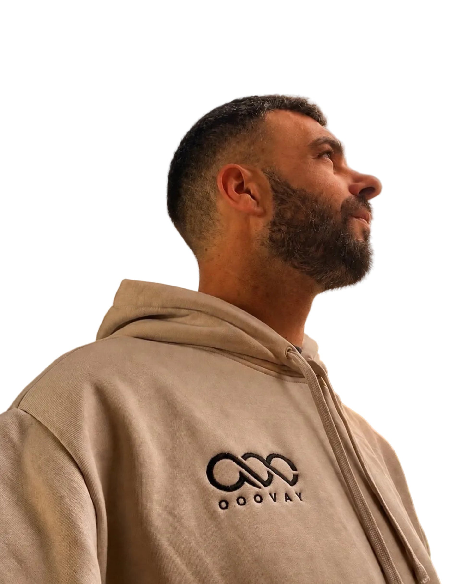Man wearing a beige hoodie with a logo on a white background