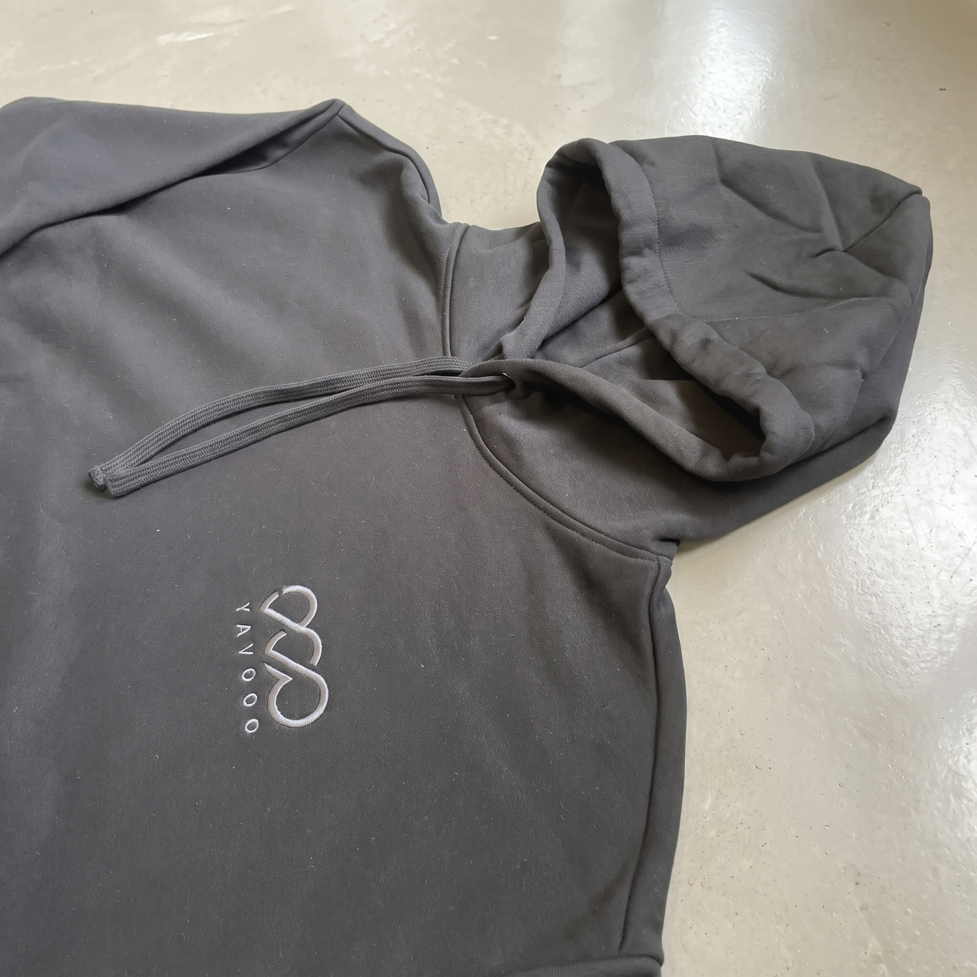 YAVOOO hoodie side seam and pocket detail, light concrete background