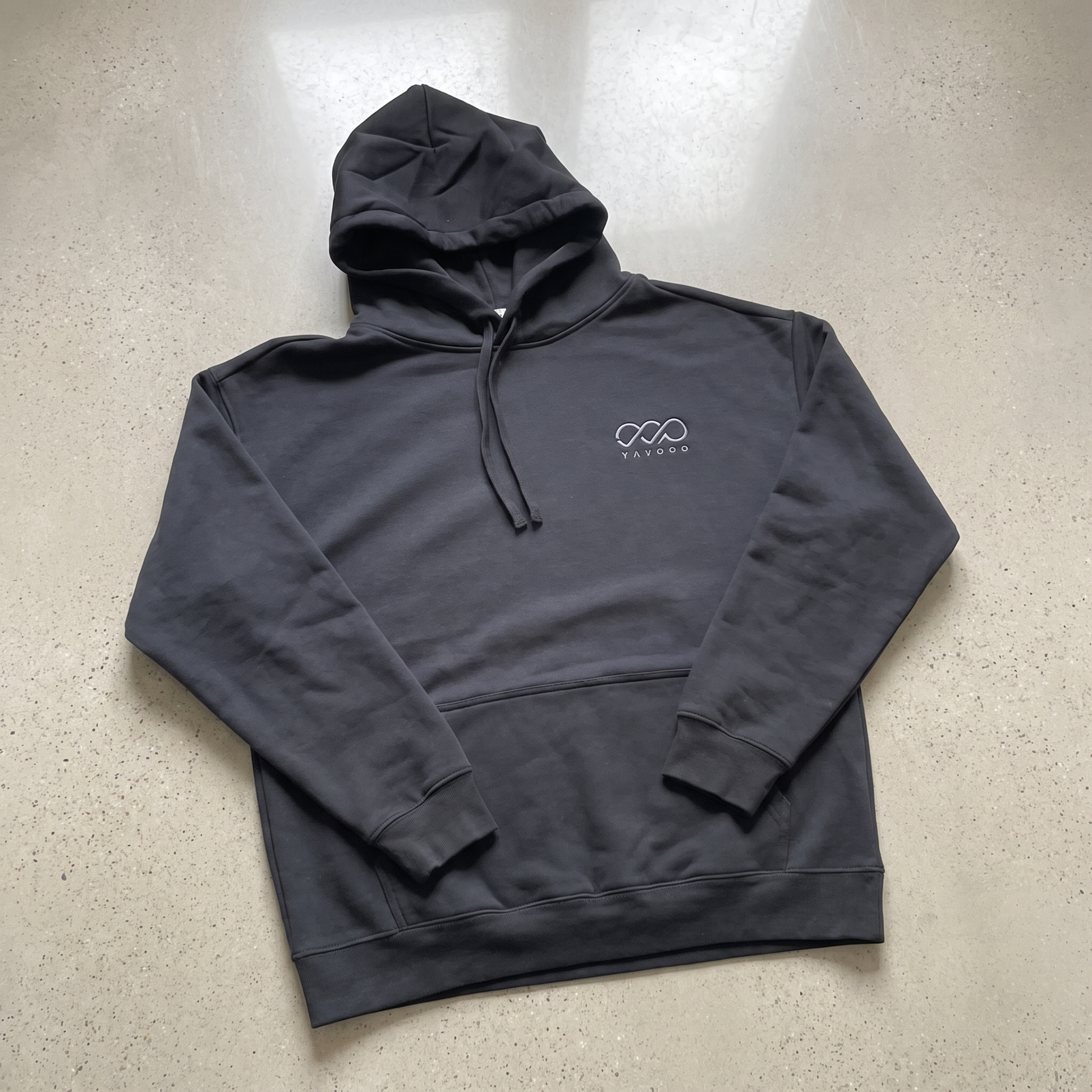 YAVOOO hoodie hood laid flat, light concrete background