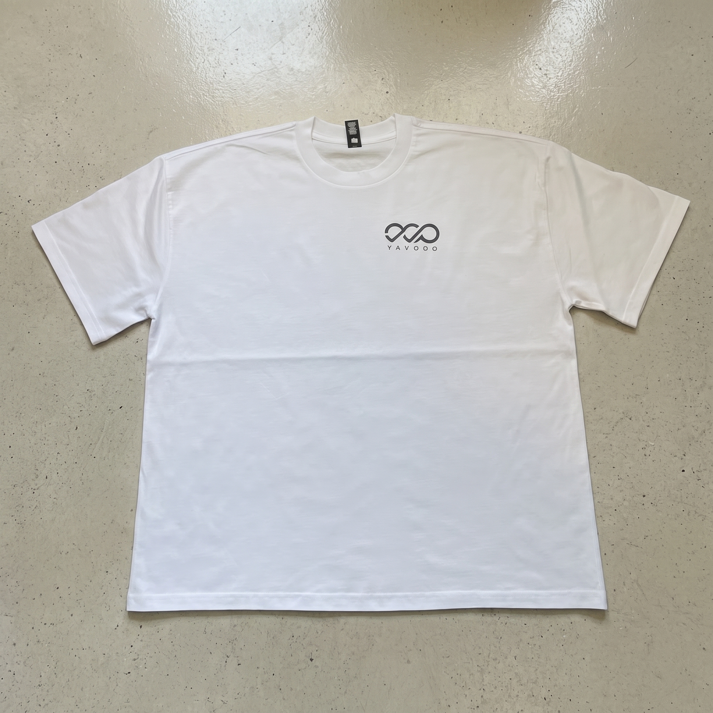 YAVOOO oversized tee shoulder and logo detail, light concrete background