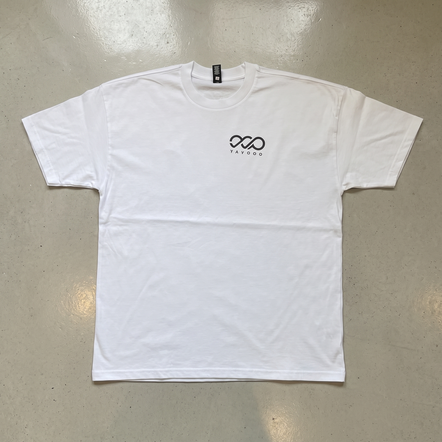 YAVOOO oversized tee laid flat, light concrete background