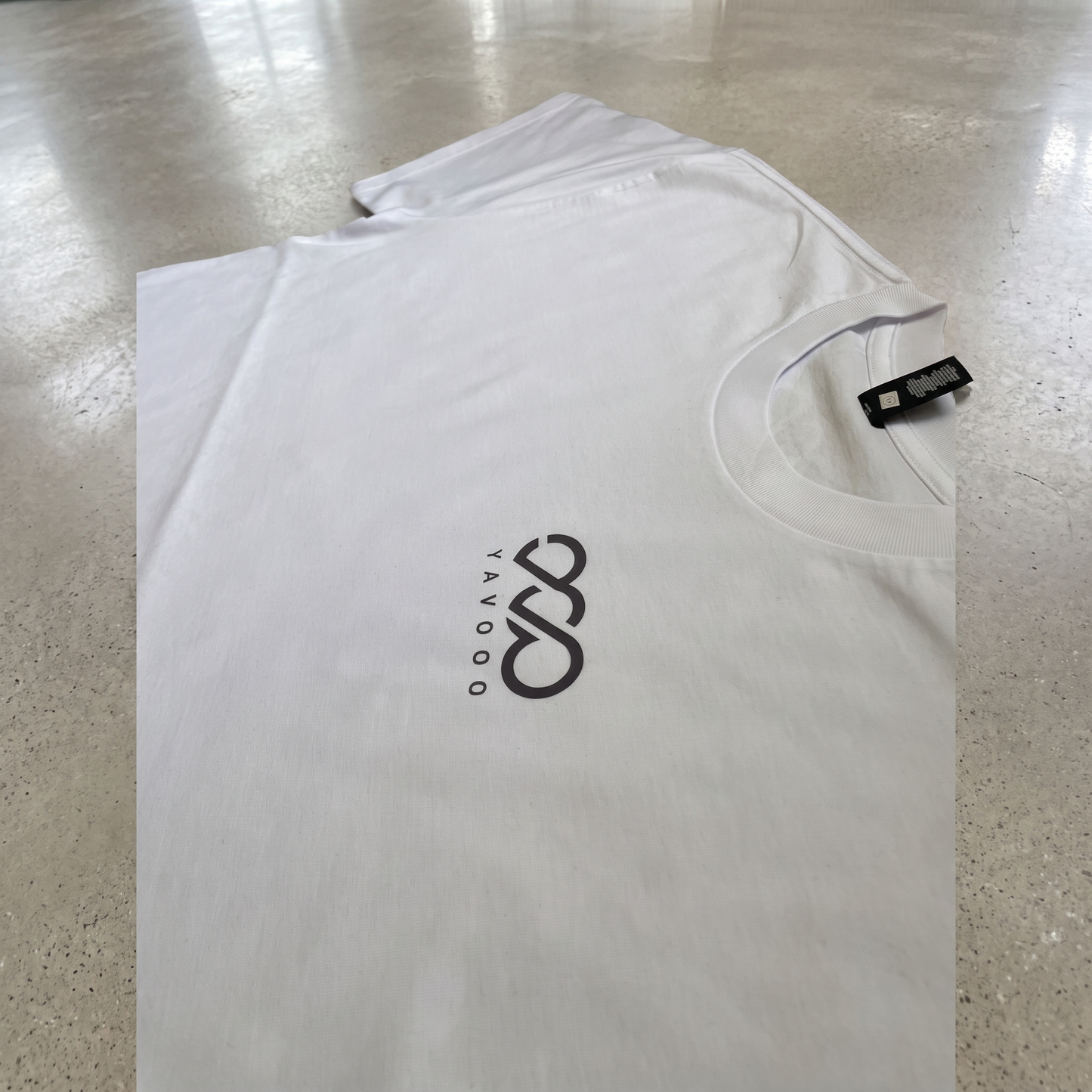 YAVOOO oversized tee shoulder and collar detail, light concrete background