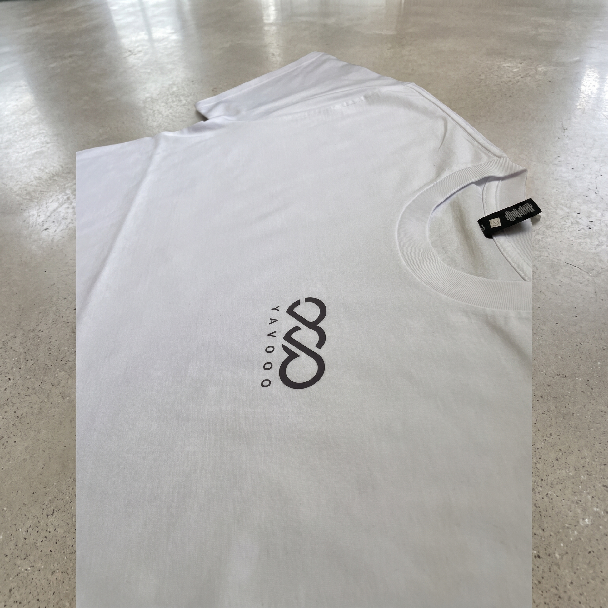 YAVOOO oversized tee shoulder and collar detail, light concrete background