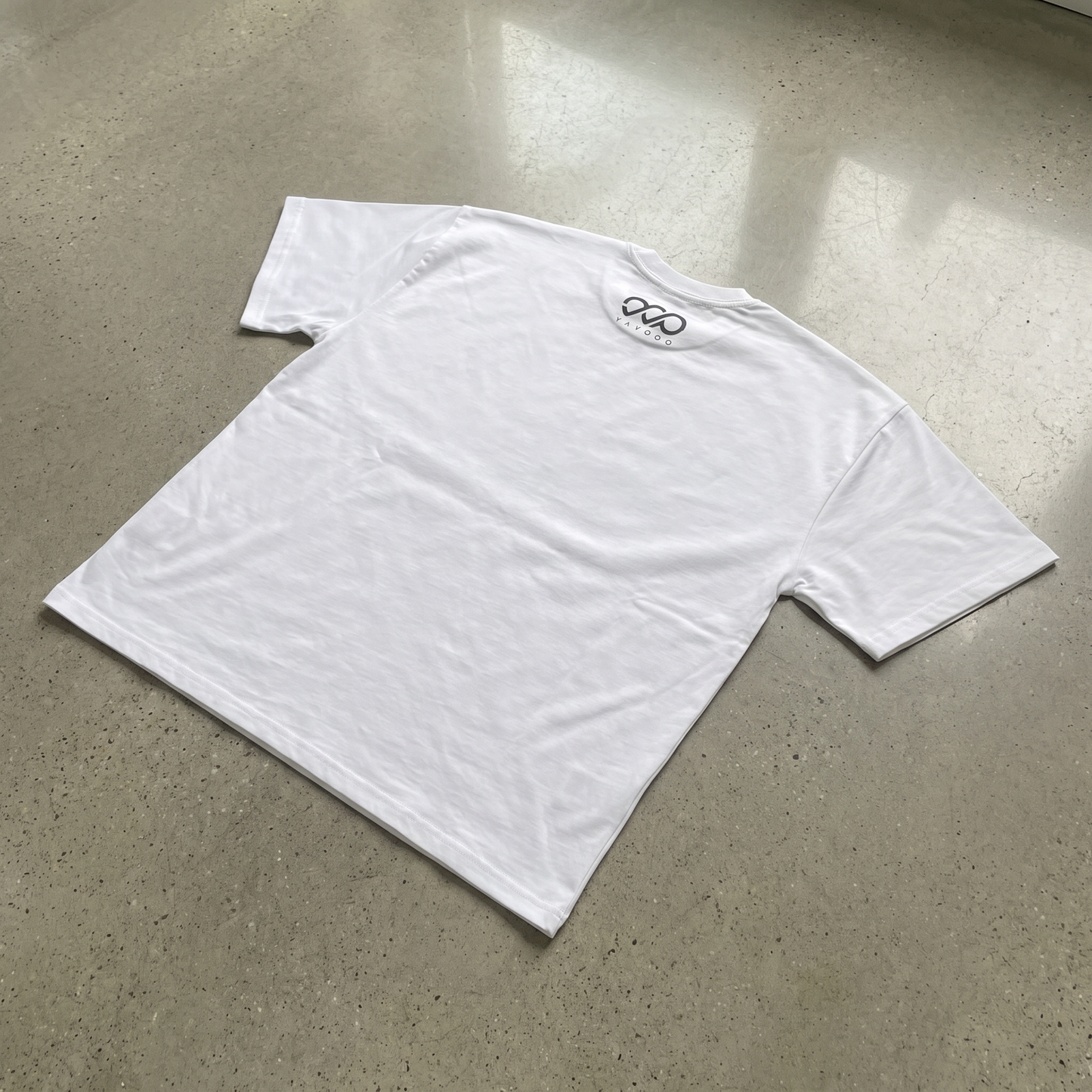 YAVOOO oversized tee laid flat full front, light concrete background